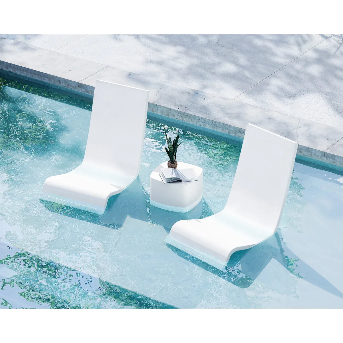 Two white lounge chairs and a small table with a plant in a pool.